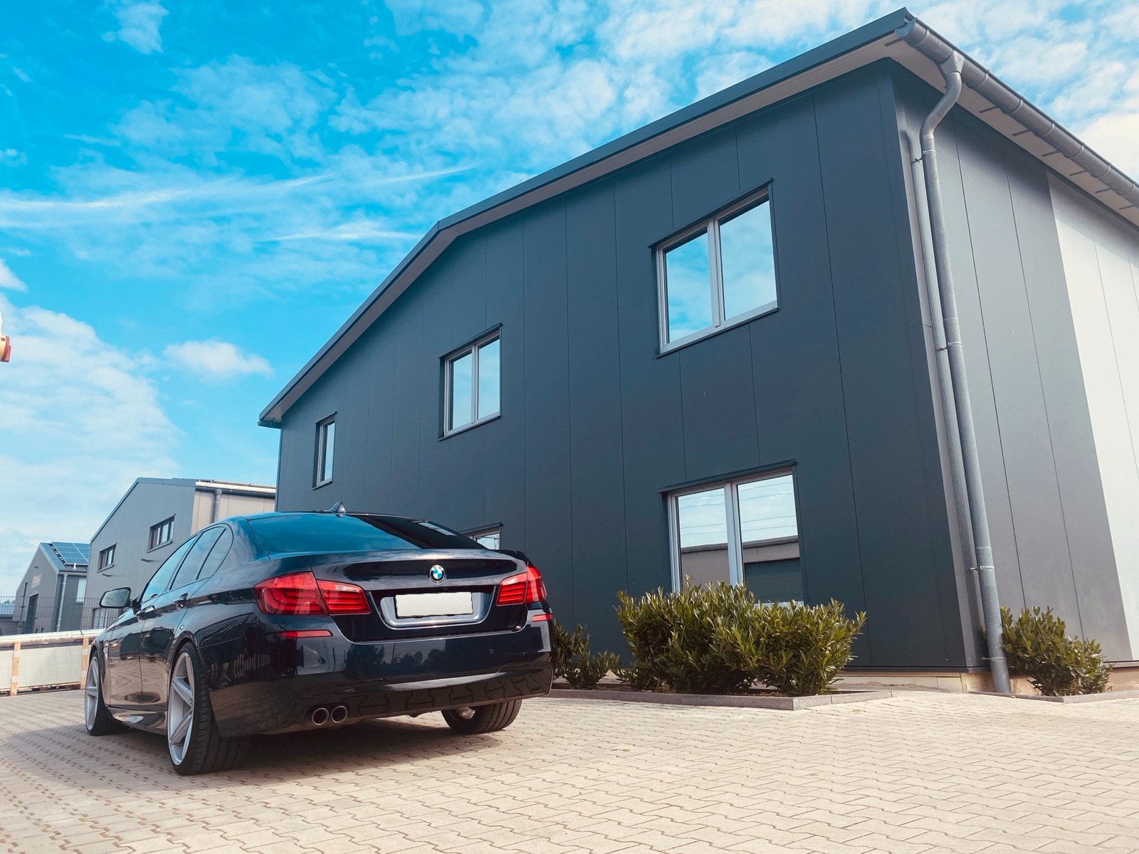 Werkstattgebäude von LEDOLEX in Gronau, davor ein schwarzer BMW 5er
